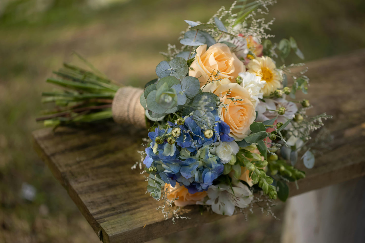 Bouquet of flowers on a wooden surface with a blurred natural background