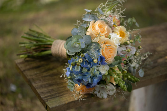 Bouquet of flowers on a wooden surface with a blurred natural background