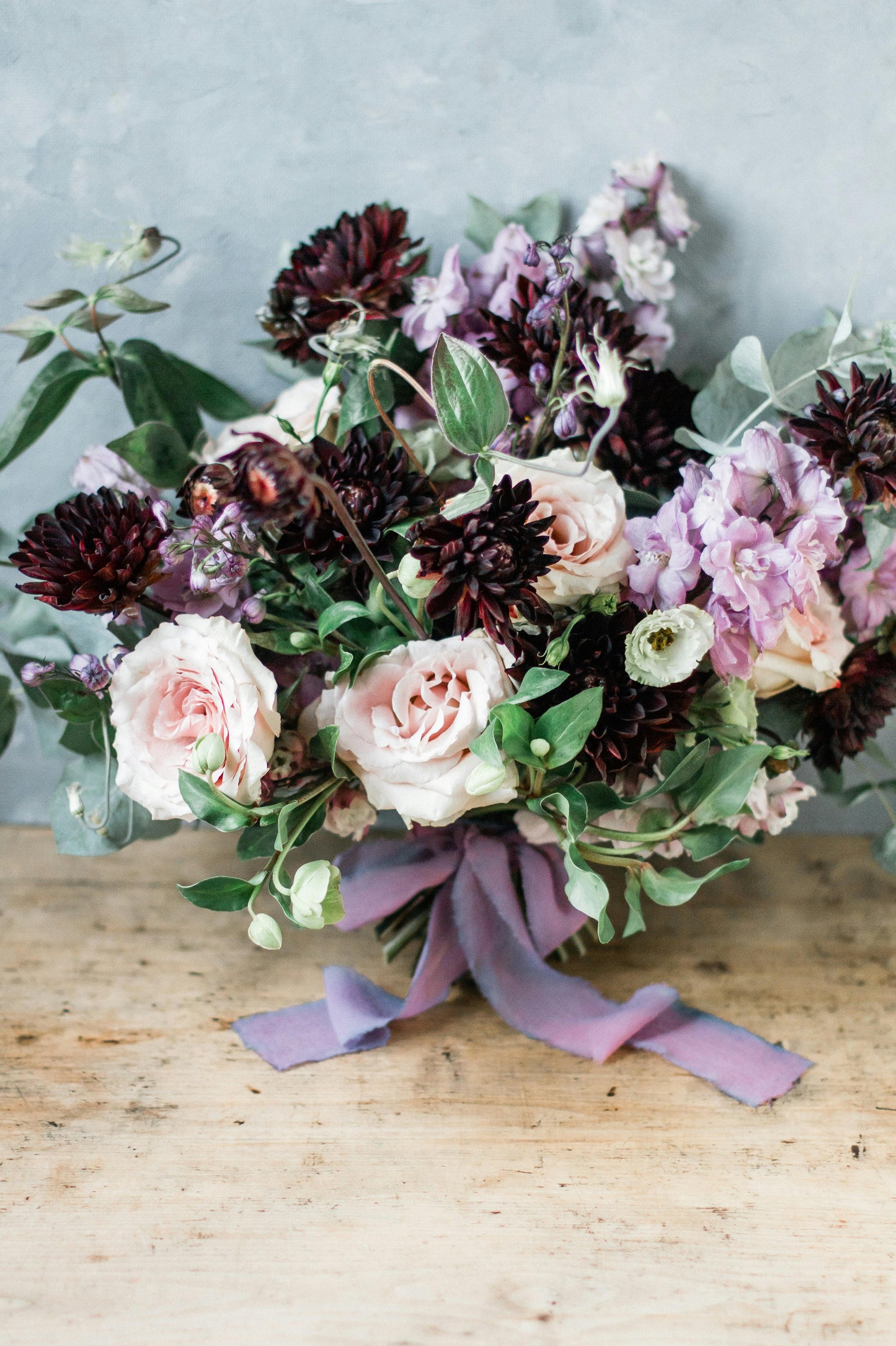 Bouquet of flowers with a purple ribbon on a wooden surface